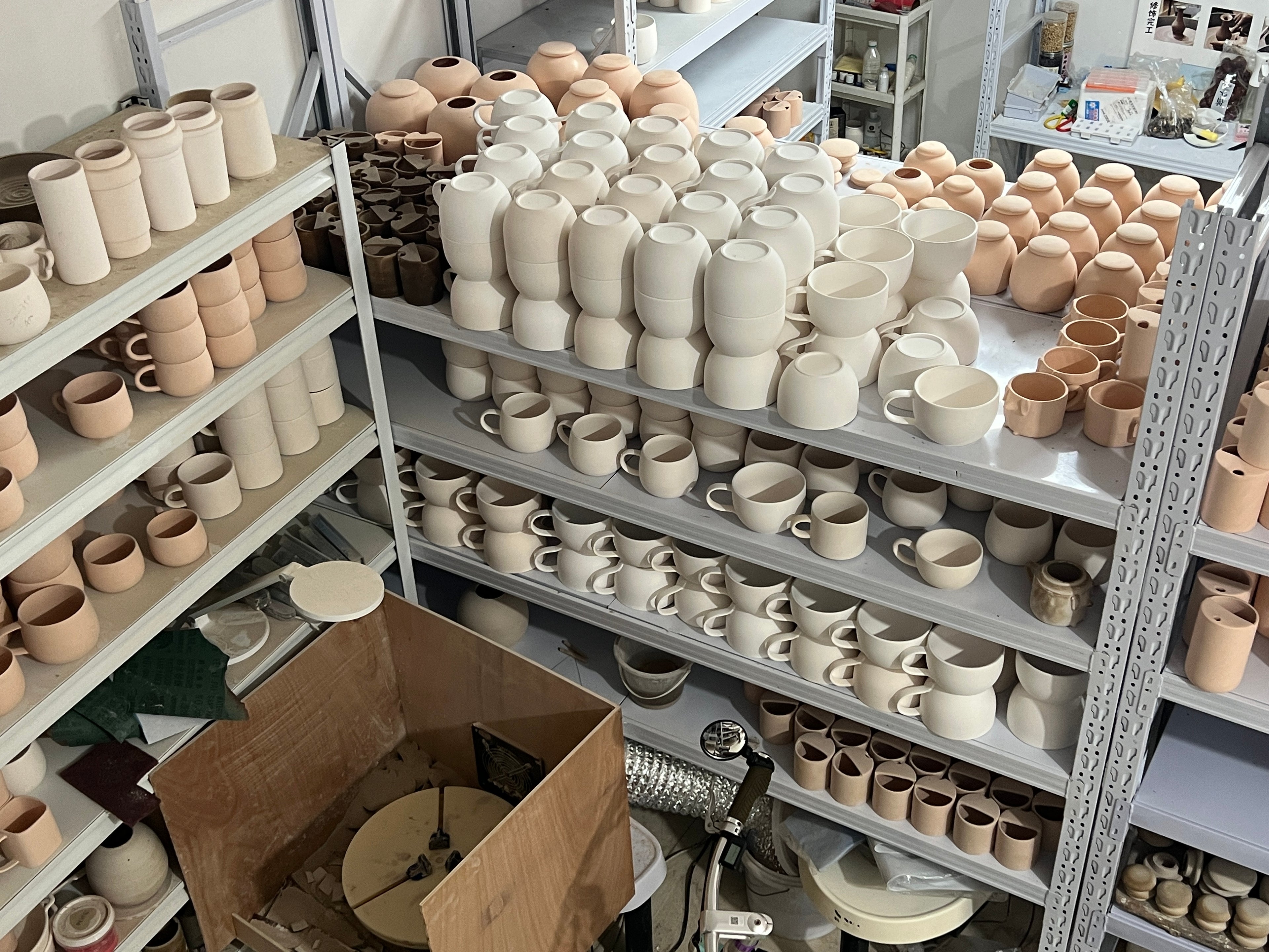 Atelier Maison Scott avec des tasses, bols et pièces en céramique brute avant peinture et personnalisation